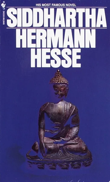 Blue book cover of "Siddhartha" by Hermann Hesse featuring a bronze Buddha statue in a meditative pose. Bold white text dominates the top half.