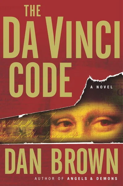 Book cover of "The Da Vinci Code" by Dan Brown features large yellow text on a red background with Mona Lisa's eyes and hidden script beneath. Mysterious tone.
