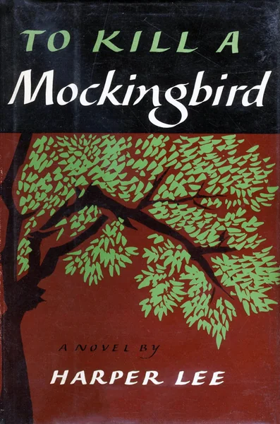 Vintage book cover of "To Kill a Mockingbird" by Harper Lee features a dark tree with green leaves on a brown background, with bold title text.